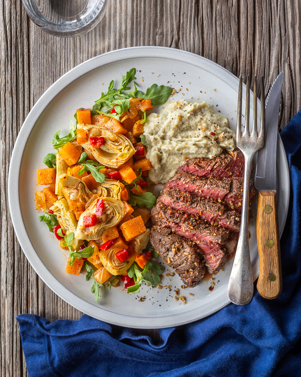 https://primalwellness.coach/wp-content/uploads/2023/08/Montreal-Steak-Seasoned-Beef-with-Fennel-Mash-and-Rutabaga-Hash-Artichoke-Salad.jpg